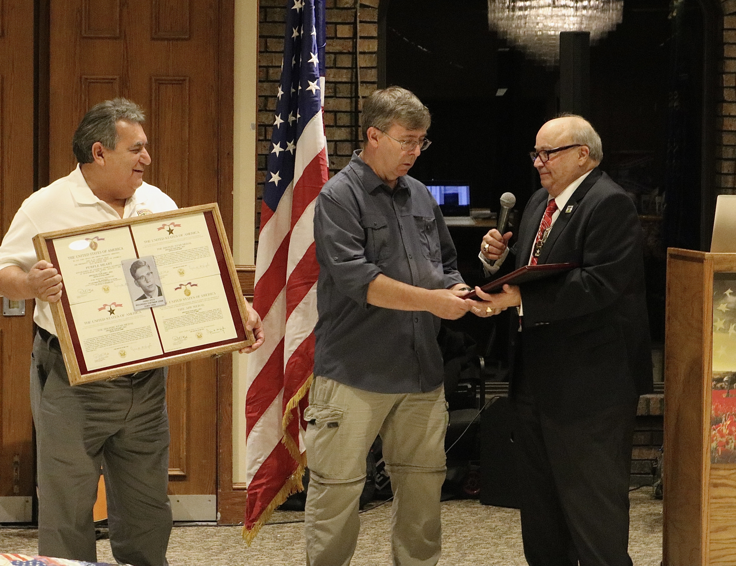 Bob Carnagey, Senior Vice Commander of the Disabled American Veterans (DAV) Department of Indiana presents LCHS teacher Tom Clark with an Americanism Award for his work in keeping the spirit of Vietnam Veterans alive. Also, in the picture is fellow veteran and Dyer Central graduate Anthony Gutierrez.