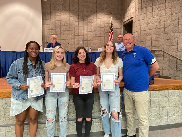 The Board recognized the girls' swimming state winners along with Coach Kilinski.