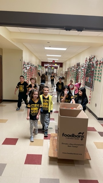 Protsman Elementary students move food collected for the food bank to the front door for pickup.