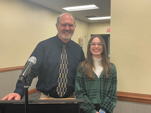 Audrey Bergman, winner of the 2023 State Solo & Ensemble Gold for Outstanding Performance, is congratulated by Mr. Graber at our Board meeting on 4/3/23.