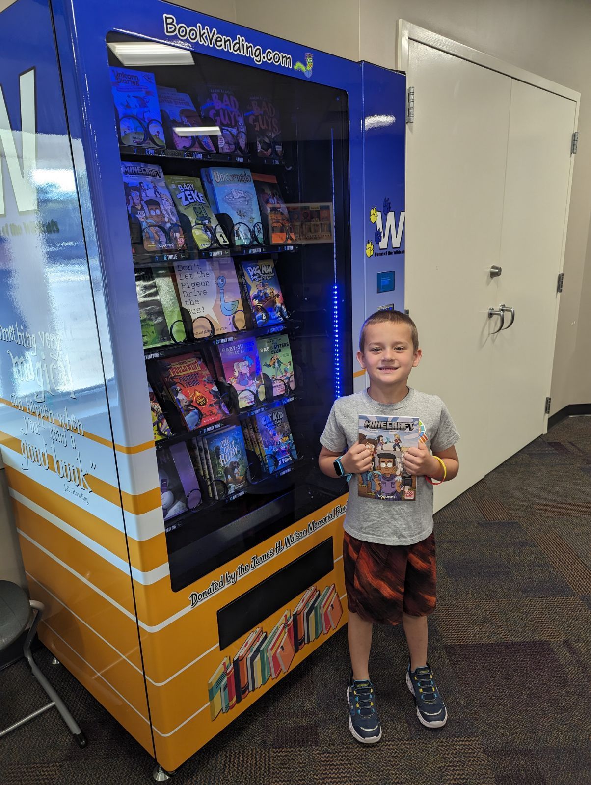 Ethan Augustyn is the first student at Watson to use the book vending machine in the office. Students receive a token on their birthday and are allowed to select a book from the vending machine.