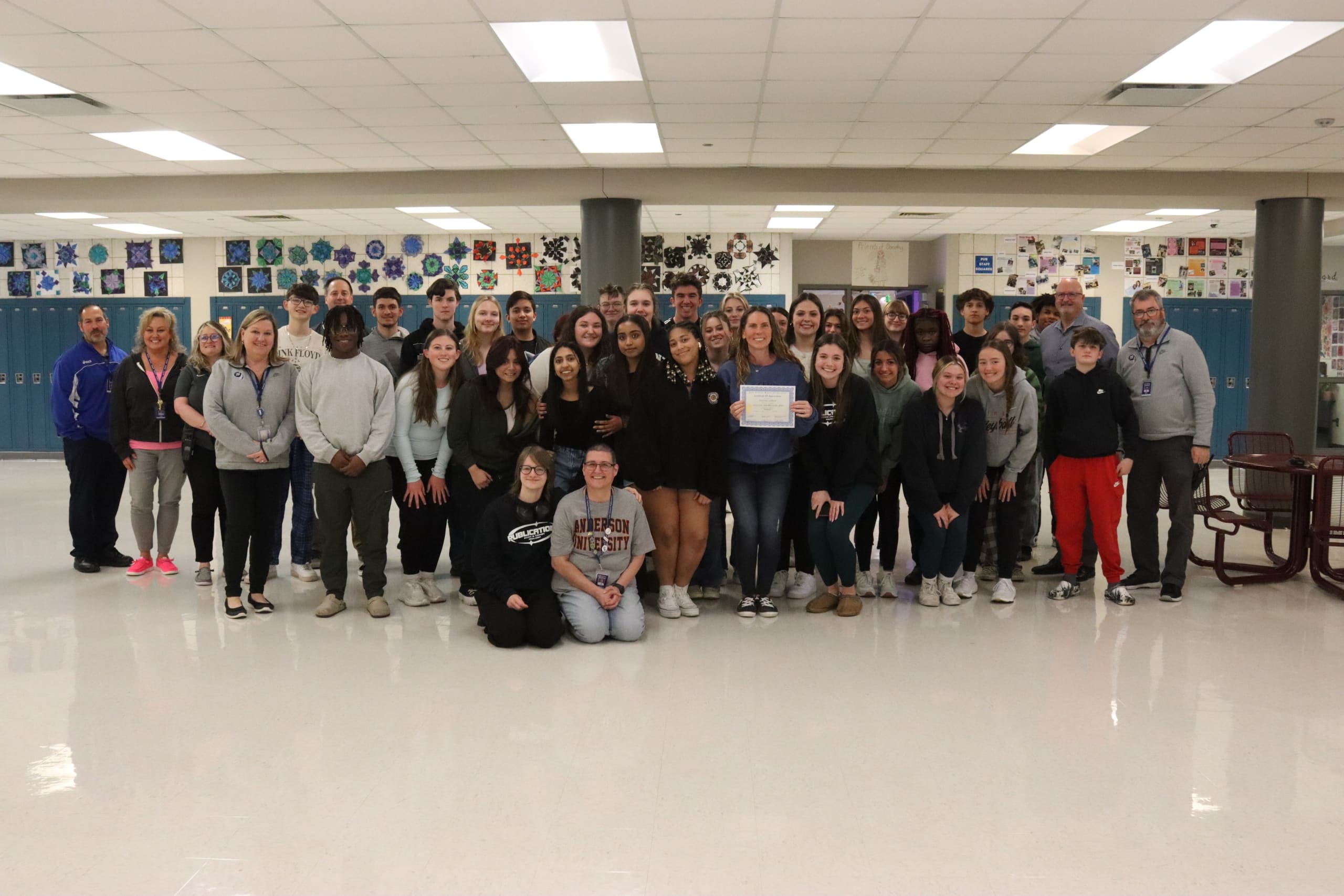 Mrs. Collard, LCHS teacher proudly poses for a picture along with administration and publications students after being named Teacher of the Year.
